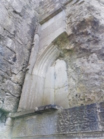 Series of carved stones including plaques with writing inserted into the northeast corner of the church at Askeaton Friary.